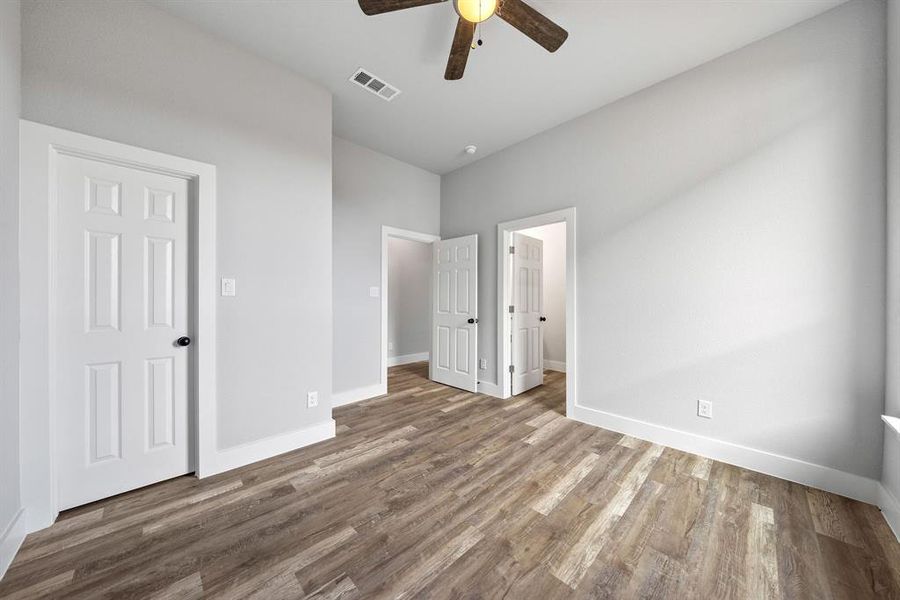 Unfurnished bedroom featuring wood finished floors and a ceiling fan