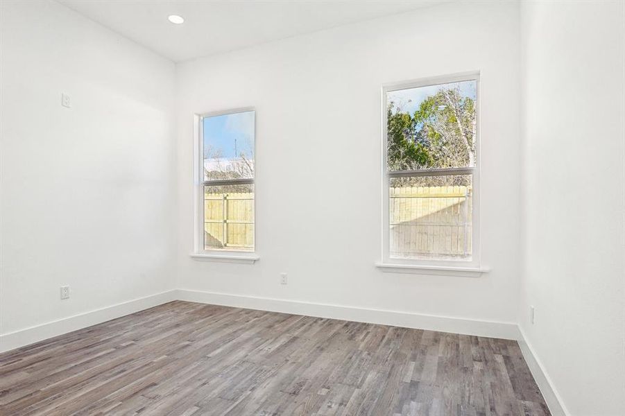 Empty room with baseboards, wood finished floors, and recessed lighting