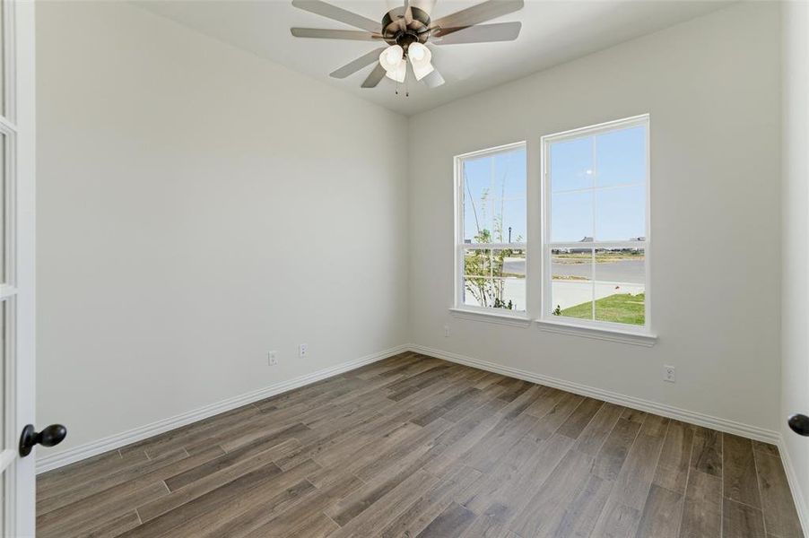 Spare room featuring a ceiling fan and dark wood-style flooring Spare room featuring a ceiling fan and dark wood-style flooring