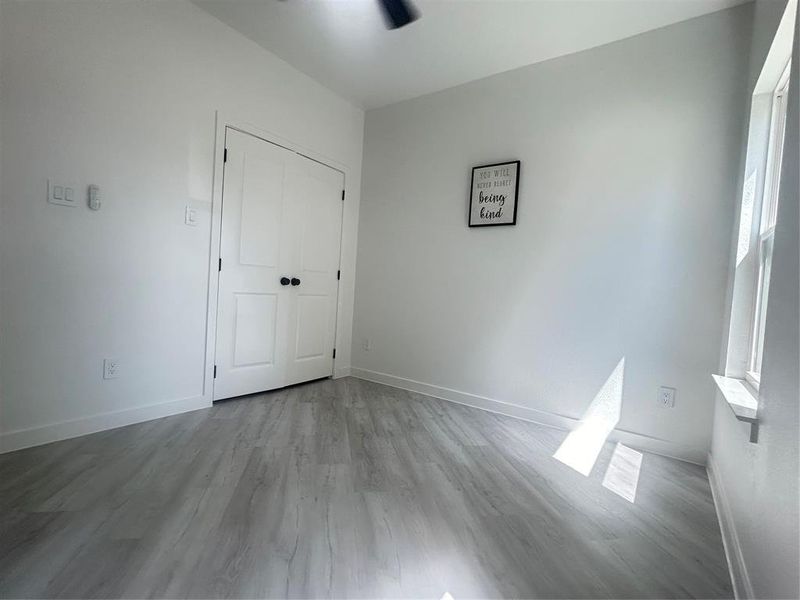 Unfurnished bedroom featuring ceiling fan, light hardwood / wood-style flooring, and a closet