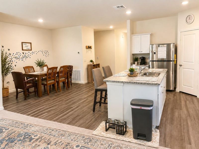 Beautiful kitchen featuring granite countertops, stainless steel appliances, abundant cabinetry, and a large center island with seating, all overlooking the main living area Beautiful kitchen featuring granite countertops, stainless steel appliances, abundant cabinetry, and a large center island with seating, all overlooking the main living area