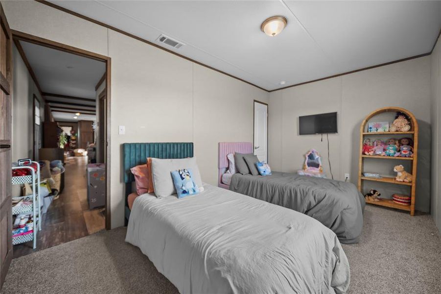 Bedroom with crown molding and carpet floors Bedroom with crown molding and carpet floors