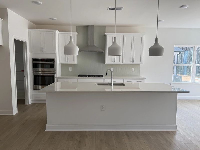 Kitchen featuring the AW Collection® Coastal - White cabinets and sea-glass tile backsplash. Kitchen featuring the AW Collection® Coastal - White cabinets and sea-glass tile backsplash.