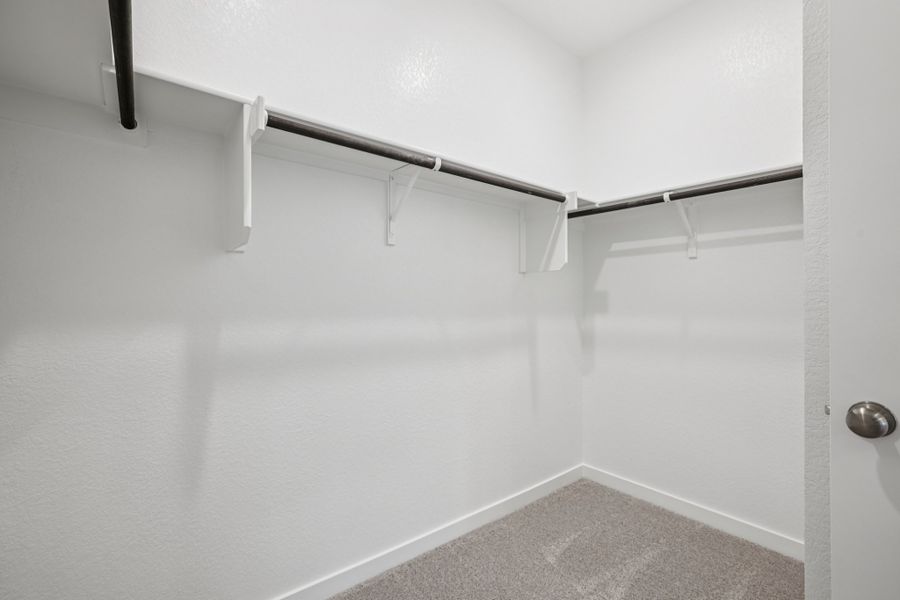 A white wall with a metal bar.