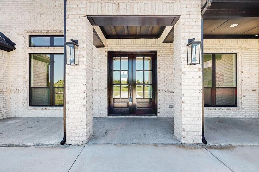 Entrance to property featuring french doors and brick siding