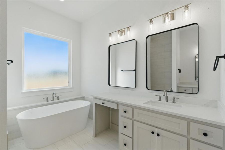 Bathroom with a freestanding tub, vanity, and light tile patterned floors Bathroom with a freestanding tub, vanity, and light tile patterned floors