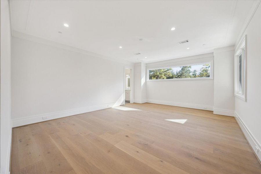 One of four en-suite secondary bedrooms on the second floor. This spacious bedroom has double French doors, en-suite bath with walk-in shower and a walk-in closet with custom built-ins.
