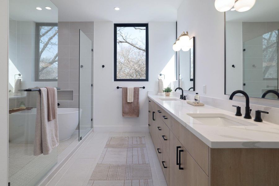 Bathroom with double vanity, a freestanding bath, tiled shower, light tile patterned flooring, and recessed lighting