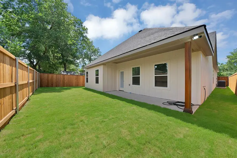 Private backyard featuring a concrete patio, wood privacy fencing, and a manicured lawn Private backyard featuring a concrete patio, wood privacy fencing, and a manicured lawn