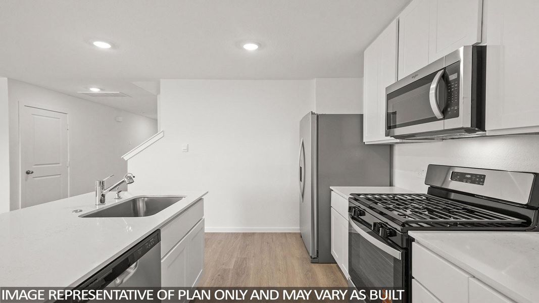 A well-lit kitchen with sleek stainless steel appliances and ample counter space for culinary endeavors.