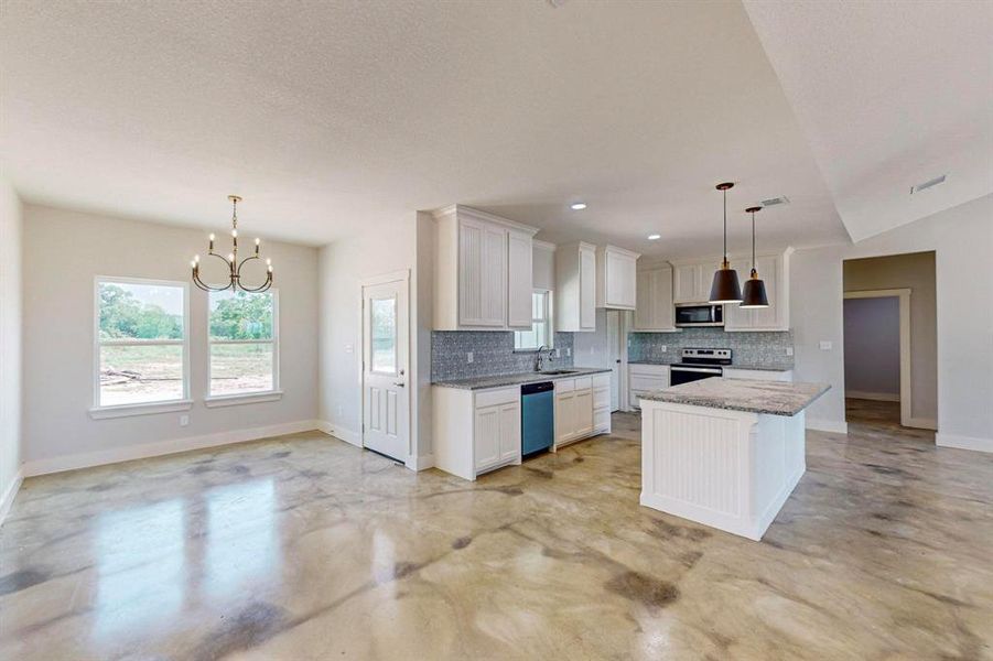 Kitchen featuring white cabinets, a kitchen island, pendant lighting, and appliances with stainless steel finishes