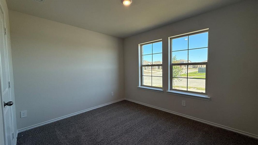 Room featuring two grid-pattern windows, neutral wall tones, and dark gray carpet