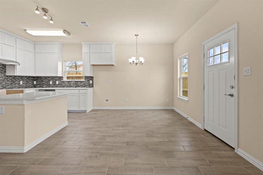 Kitchen with plenty of natural light, a sink, visible vents, and decorative backsplash