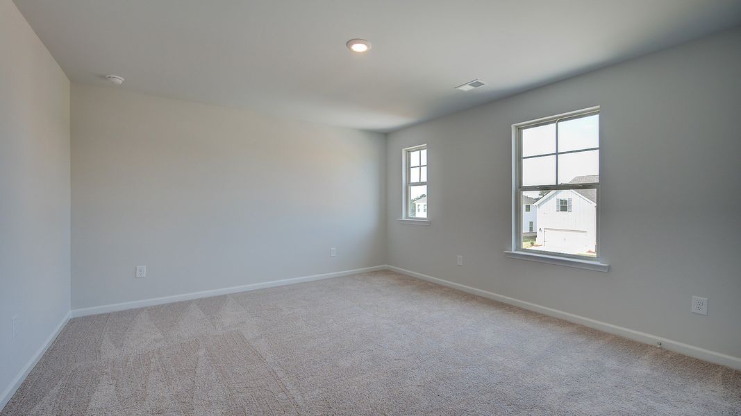 Secondary bedroom with carpet flooring and natural light in the McKinley II at Brighton in Locust Grove, GA.
