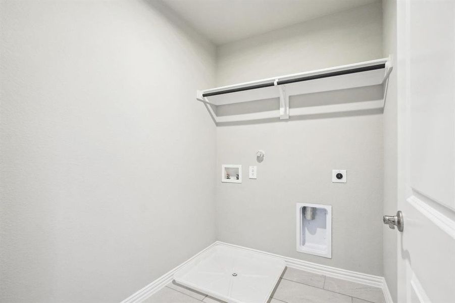 Laundry room with hookup for a gas dryer, light tile patterned floors, electric dryer hookup, and hookup for a washing machine Laundry room with hookup for a gas dryer, light tile patterned floors, electric dryer hookup, and hookup for a washing machine