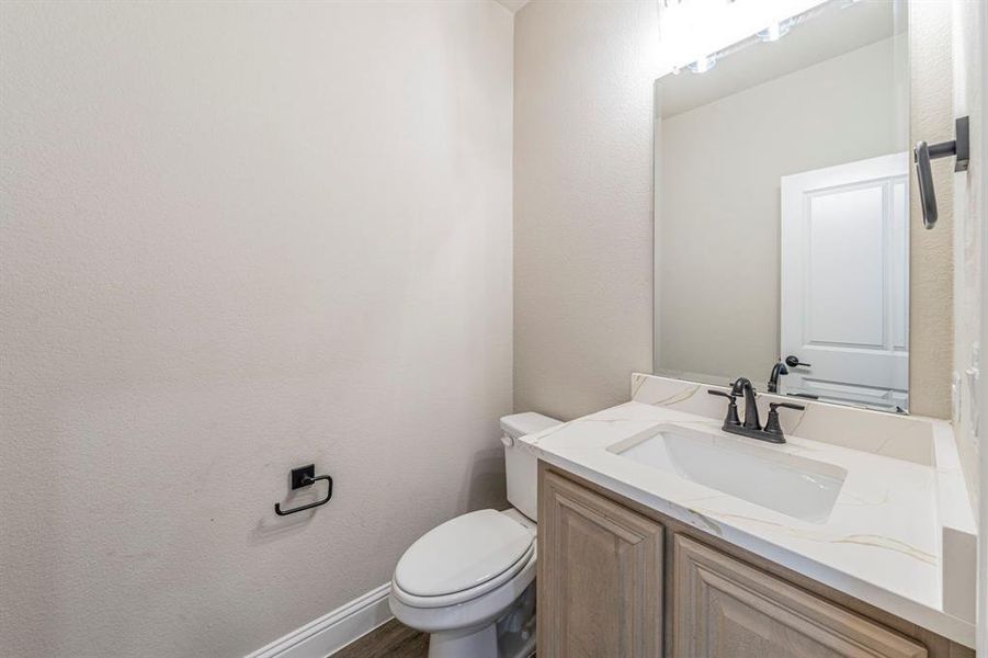 Modern bathroom featuring a single vanity with a white countertop and integrated sink, matte black faucet, and a large wall-mounted mirror