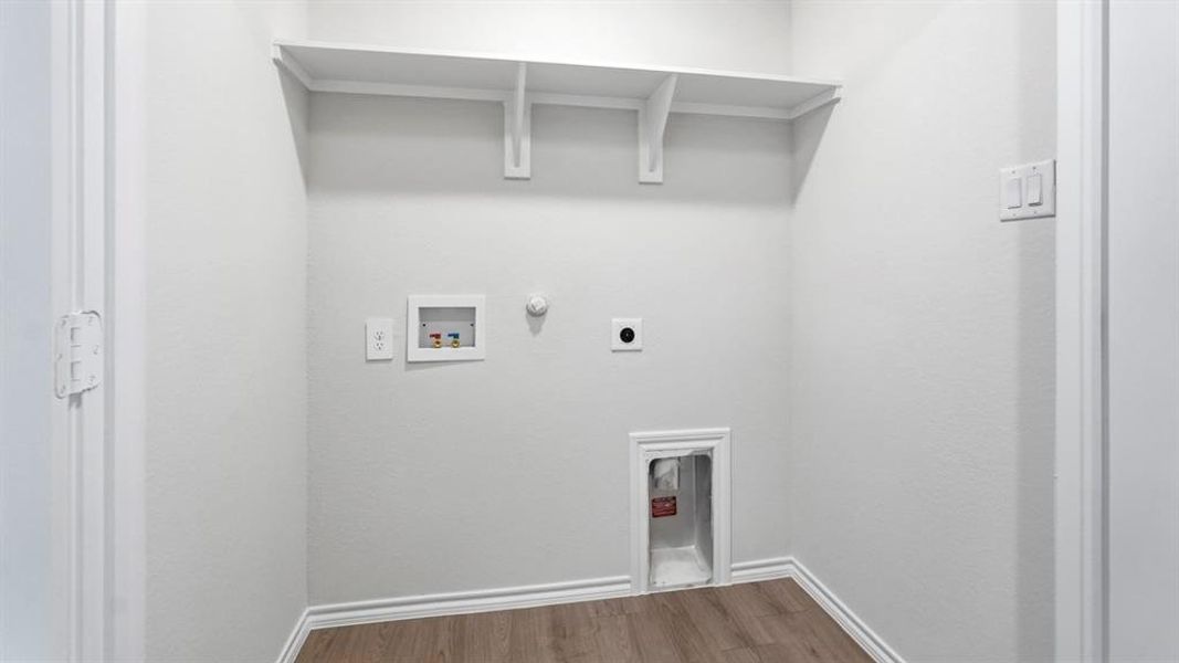 Laundry room with hookup for a gas dryer, hookup for a washing machine, wood finished floors, and electric dryer hookup Laundry room with hookup for a gas dryer, hookup for a washing machine, wood finished floors, and electric dryer hookup
