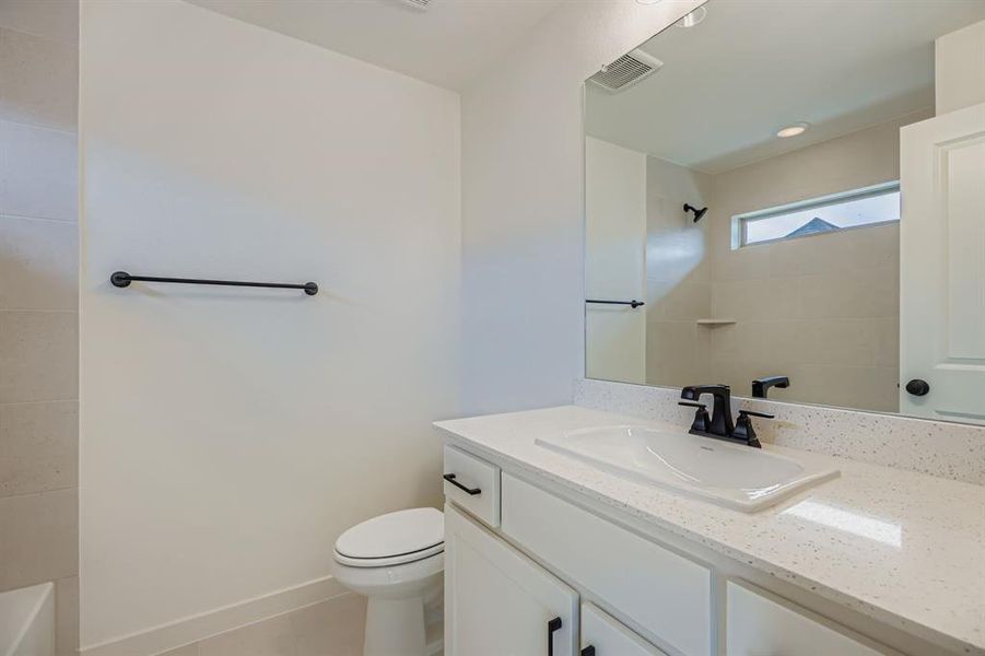Full bathroom featuring vanity and light tile patterned floors Full bathroom featuring vanity and light tile patterned floors