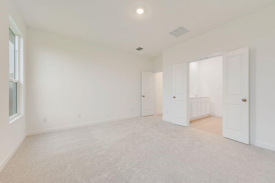 Unfurnished bedroom with light colored carpet, ensuite bathroom, and recessed lighting Unfurnished bedroom with light colored carpet, ensuite bathroom, and recessed lighting