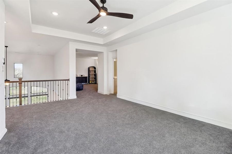 Unfurnished room featuring carpet flooring, a raised ceiling, ceiling fan, visible vents, and recessed lighting Unfurnished room featuring carpet flooring, a raised ceiling, ceiling fan, visible vents, and recessed lighting