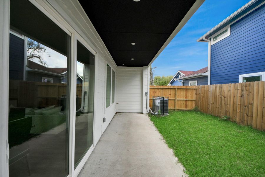 Discover a cozy backyard retreat featuring a sleek covered patio and lush lawn, perfect for relaxation and outdoor gatherings.