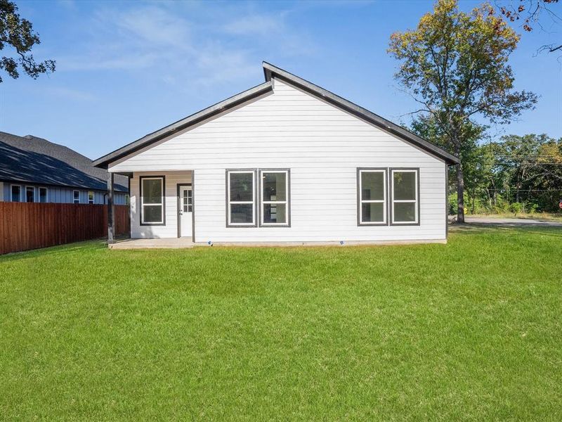 Rear view of house featuring a yard