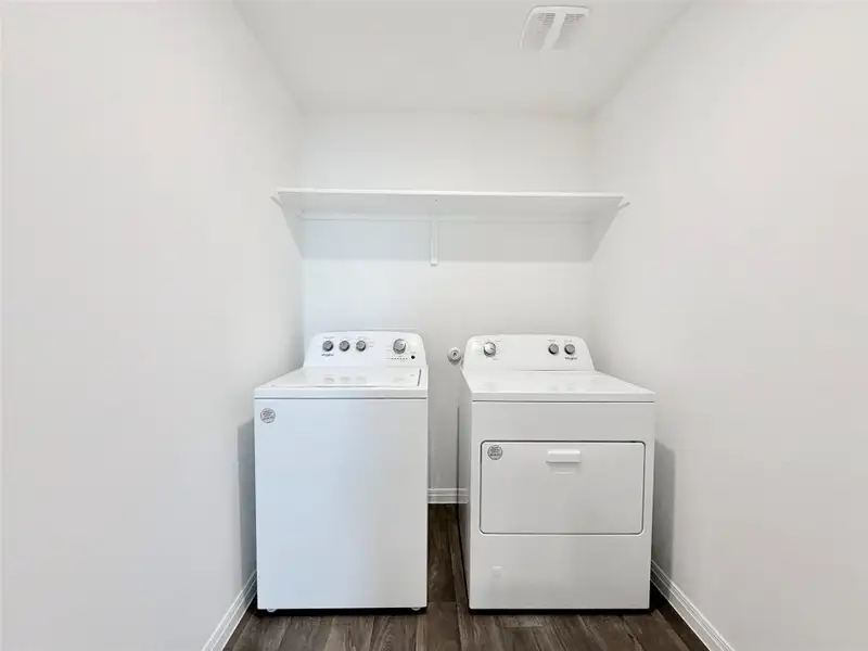 Laundry room featuring dark wood-type flooring and separate washer and dryer Laundry room featuring dark wood-type flooring and separate washer and dryer