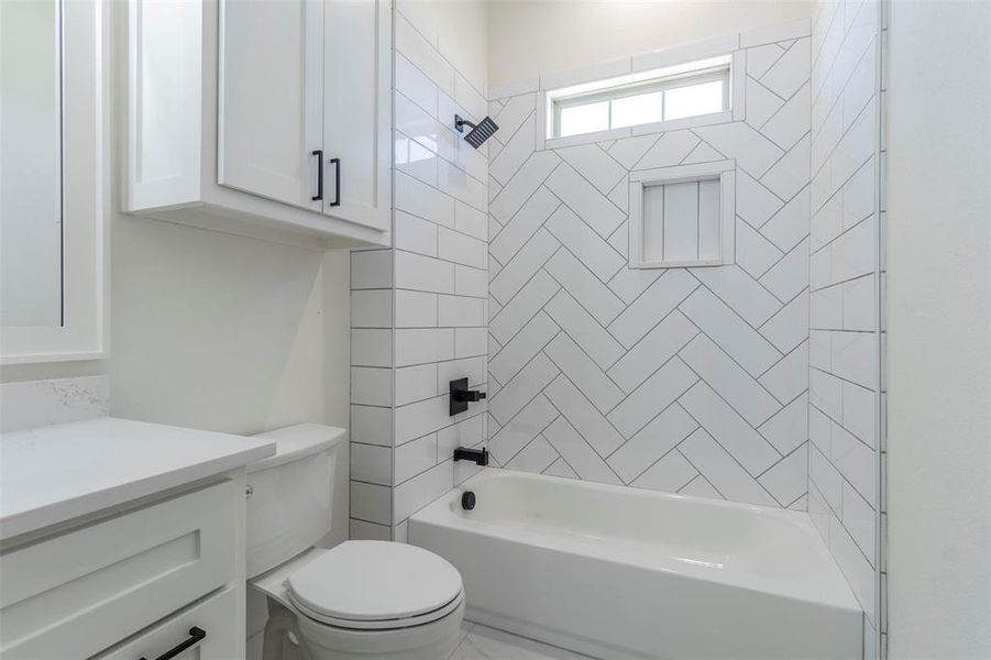 Full bathroom with vanity, toilet, and tiled shower / bath