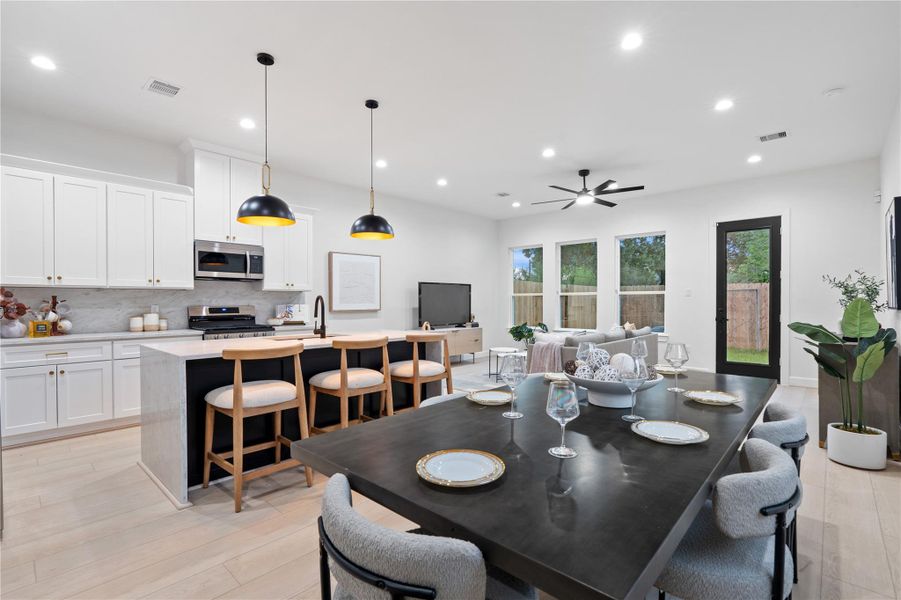 Open kitchen and dining concept with quartz waterfall island and designer pendant lighting. Open kitchen and dining concept with quartz waterfall island and designer pendant lighting.