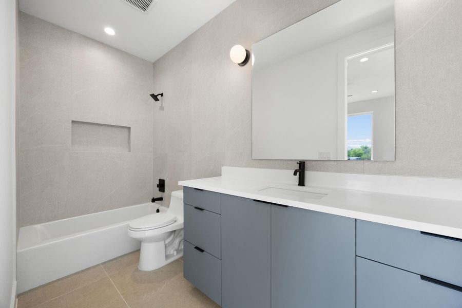 A well-appointed bathroom features a modern vanity and clean-lined tub-shower combination with sleek fixtures.