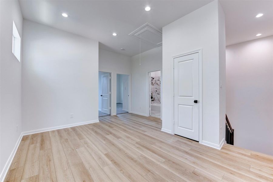 Atop stair landing a versatile flex space offers endless possibilities, perfect for a home office, media room, or gym, all complemented by recessed lighting and a clean, neutral finish.