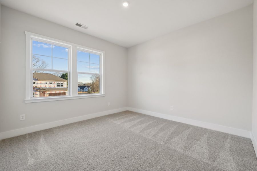 A room with a window and a carpet.