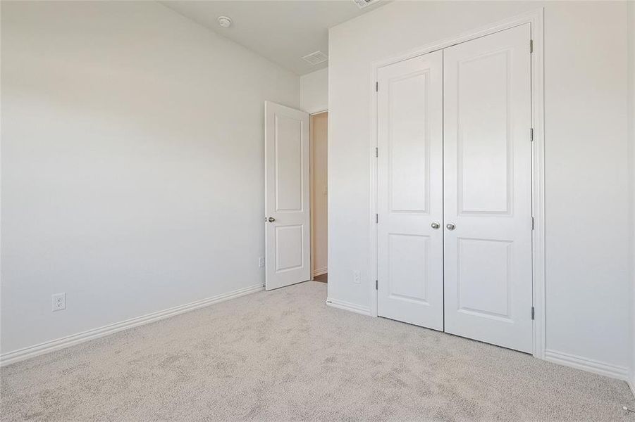 Unfurnished bedroom featuring light colored carpet and a closet