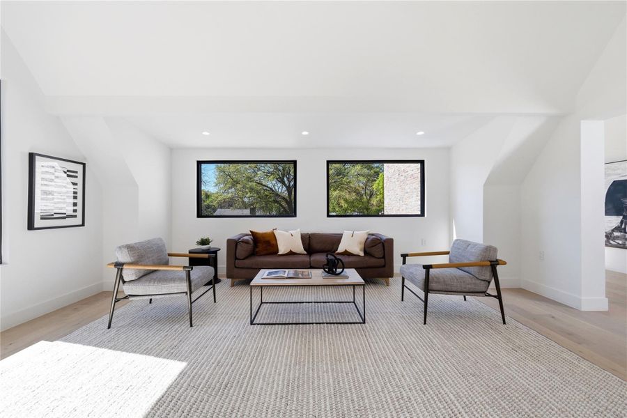 Living room with lofted ceiling, light wood-type flooring, and recessed lighting