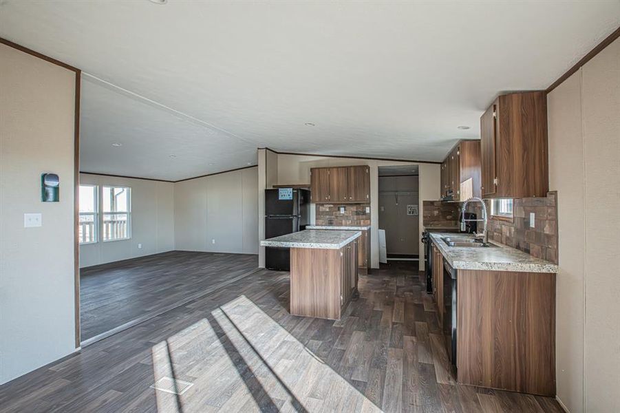 Kitchen with decorative backsplash, recessed lighting, black appliances, a kitchen island