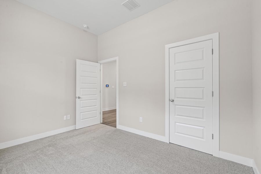 Unfurnished bedroom with baseboards and carpet