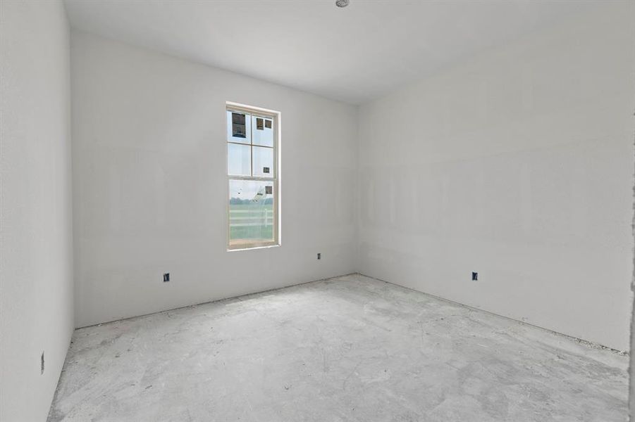 Room with a window, white walls, and concrete flooring Room with a window, white walls, and concrete flooring