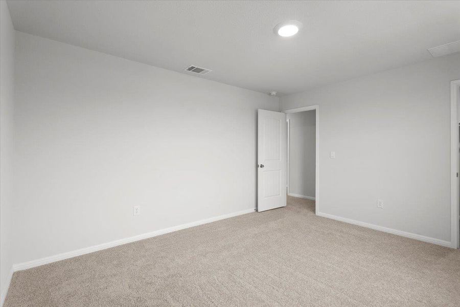 Spacious room featuring neutral carpeting and light gray walls
