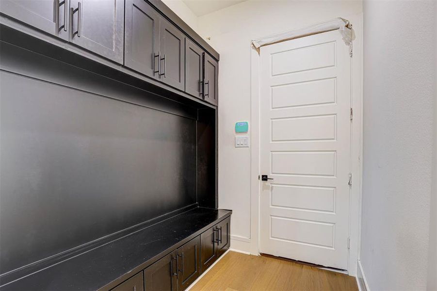 Mudroom with light wood-style flooring and baseboards