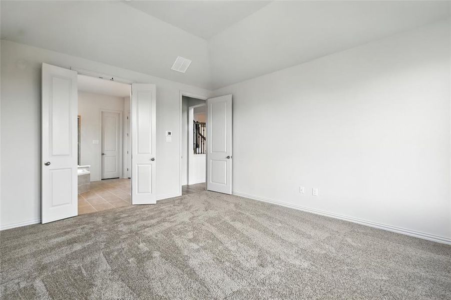 Unfurnished bedroom featuring light colored carpet and light tile patterned flooring