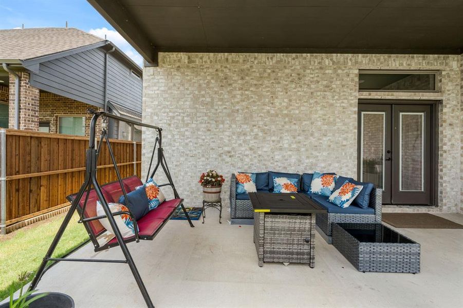 Covered outdoor patio featuring light-colored brick exterior, concrete flooring, and an opaque overhead ceiling Covered outdoor patio featuring light-colored brick exterior, concrete flooring, and an opaque overhead ceiling