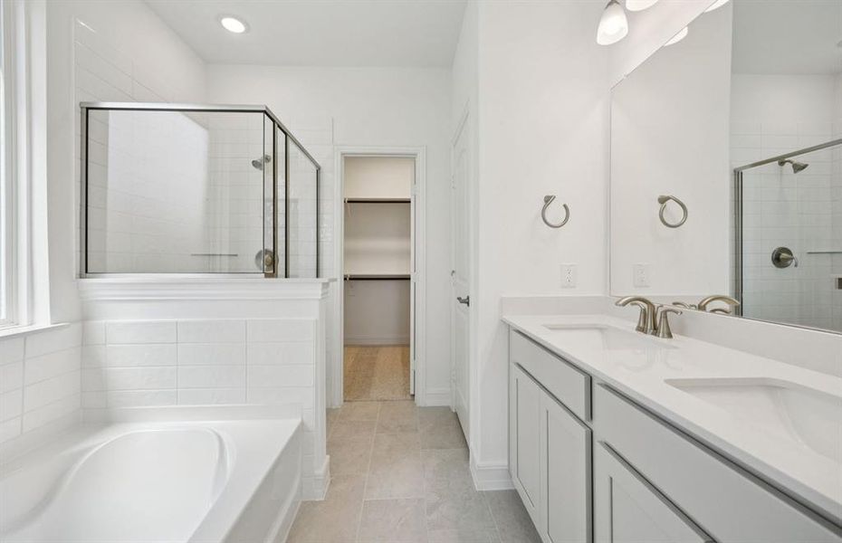 Elegant owner's bathroom with dual vanity and oversized shower *real home pictured