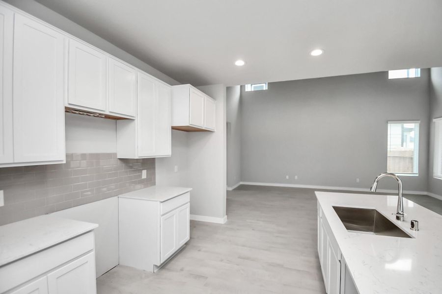 Discover another perspective of this stunning kitchen, generously appointed with an abundance of counter space. Sample photo of completed home with similar floor plan. Actual colors and selections may vary.