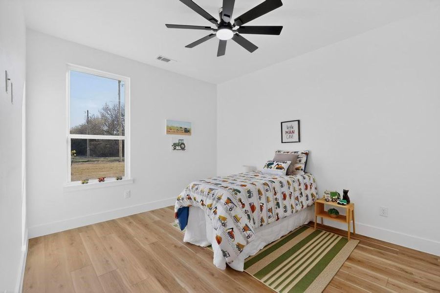 Bedroom featuring light wood-style flooring and ceiling fan Bedroom featuring light wood-style flooring and ceiling fan