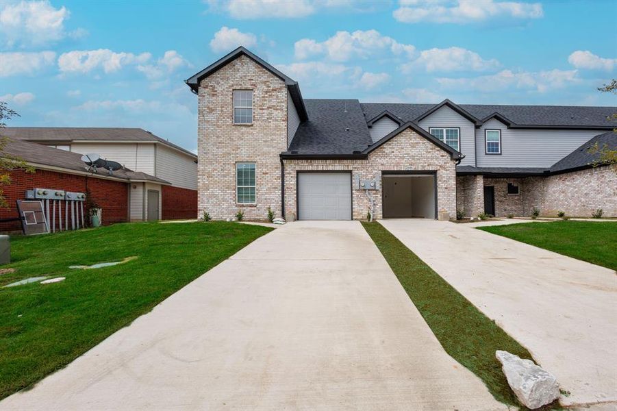 View of front of property featuring a garage and a front yard