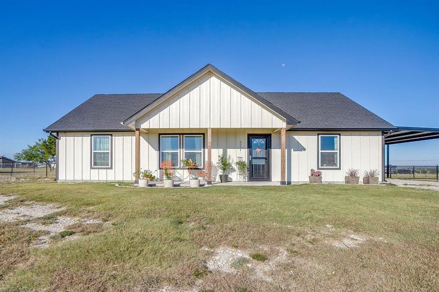 Modern farmhouse style home featuring covered porch with seating area, a shingled roof, siding, and an attached carport Modern farmhouse style home featuring covered porch with seating area, a shingled roof, siding, and an attached carport