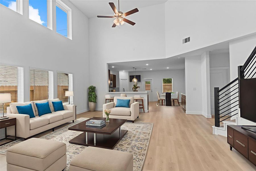 This breathtaking family room features a towering ceiling, a dramatic wall of windows, and an open connection to the kitchen and dining areas, creating the ultimate gathering space. **Image Representative of Plan Only and May Vary as Built**.