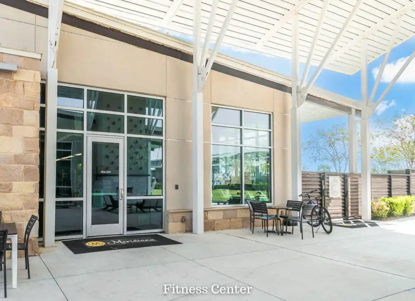 Modern fitness center with large windows, outdoor seating, and a stylish overhang for shade. Modern fitness center with large windows, outdoor seating, and a stylish overhang for shade.