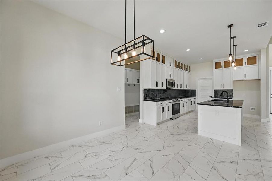 Kitchen featuring stainless steel microwave, baseboards, a sink, recessed lighting, and decorative backsplash Kitchen featuring stainless steel microwave, baseboards, a sink, recessed lighting, and decorative backsplash