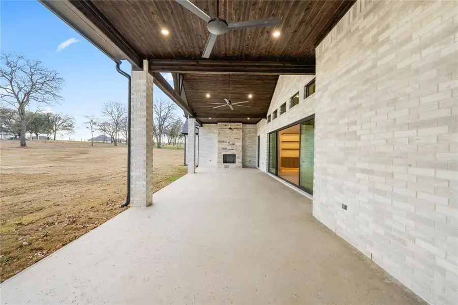 Expansive covered patio featuring a wood-plank ceiling with recessed lighting and ceiling fans